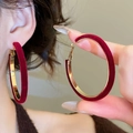 Close-up of red velvet and gold metal geometric hoop earrings on female model - Red