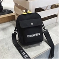 Minimalist black canvas crossbody bag with white typography and yellow zipper details - Black