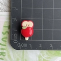 Macro view of a red resin apple popsicle charm showing size measurements on a scale - Red Apple Popsicle