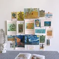 Detailed view of Van Gogh and Monet art cards displayed on a white Nordic style wall - Oil Painting Traces