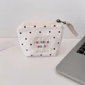 Close-up of white canvas mini makeup bag with black polka dots and zipper detail - Crinkled Fabric Polka Dot