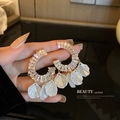 Detailed shot of gold hoop earrings featuring crystal inlay and elegant white flower petals - Gold Shell Tassel (2#)