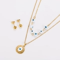 Detail of gold evil eye jewelry set with layered necklace and round hammered pendant - Gold White