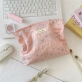 Vista plana de neceser rosa con textura de jacquard y accesorios en escritorio - Rosa
