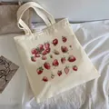 Off-white canvas tote bag with red strawberry prints on a white fabric background - C8 All-over Strawberry