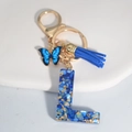 Royal blue resin letter L keychain with gold foil, butterfly charm, and soft tassel - Letter L