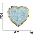 Gedetailleerde weergave van 5cm blauwe chenille hartpatch met gouden glitterrand, 2g - Blauw Hart (Maat 10)