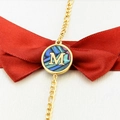 Macro shot of 18k gold plated bracelet with a round M letter abalone shell pendant - Letter M