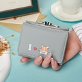 Grey trifold wallet with Corgi print and metal kiss-lock closure shown in hand - Blue