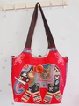 Detail einer roten Segeltuchtasche mit bunter Elefantenstickerei und Holzknopfverschluss - Stil 18-Rot Elefantenstickerei