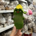 Handmade crochet pickle doll with yellow flower holding a white encouragement card - Pickle With Leaf
