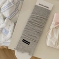 Light gray ribbed leg warmers with ruffle trim and brand label on a display card - One Size / Light Gray