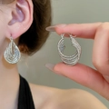 Detailed view of silver multi-layer braided twist hoop earrings on model and hand - 74# Ear Buckle - Silver Multi-Layer Woven