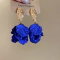 Macro-detail van koningsblauwe gelaagde bloemblaadjes met gehamerde gouden studs - Blauw