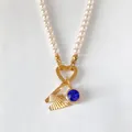 Elegant pearl necklace with faceted gold letter M and sparkling blue crystal pendant - Letter W
