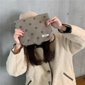 Brown polka dot corduroy storage bag held by model against a minimalist gray wall - Grey Polka Dot