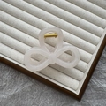 Translucent white bow hair claw clip with gold spring on a beige jewelry display - 8cm Figure 8 / Jelly White