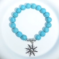 Blue turquoise bead bracelet featuring an antique silver sun charm on elastic cord - Blue Turquoise Sun Charm