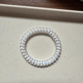 Transparent spiral phone cord hair tie with colorful sequins and lucky clover detail - Small White Meteor Dots