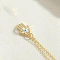 Macro shot of gold Hamsa Hand pendant with cubic zirconia and evil eye detail - White Hamsa Hand Style (XL3159-4)