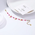 Close-up of a double-layer gold stainless steel bracelet with magenta pink beads and charms - Double-layer Rose Pink Beads Round Disc Style