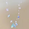Detail of multi-layer pearl necklace featuring a shimmering fish tail pendant - Style 11-White-Purple (Iridized Fish Tail Triple Layer)