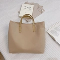 Close-up of vertical pleated beige tote bag with faux leather handles and rivet details - Khaki