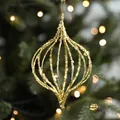 Golden glittered onion-shaped hollow Christmas ornament on a lighted tree, 15cm x 9cm - Gold Teardrop Ball