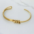Gros plan du bracelet jonc doré en acier inoxydable avec détails polis effet miroir - Nœud Asymétrique Doré (A1106)