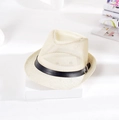 Chapeau fedora respirant avec ruban noir présenté sur un plateau élégant blanc - crème