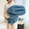 Thick navy blue faux rabbit fur blanket with wide striped texture held by a model - Rabbit Plush Blue