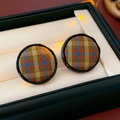 Gros plan de boucles d'oreilles circulaires en tissu avec motif écossais dans un coffret - Aiguille en argent / Vert