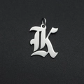 Macro detail of silver stainless steel gothic letter K pendant with polished finish - Letter K