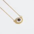 Golden Evil Eye necklace with brown pupil and white crystal lashes on ivory background - Brown