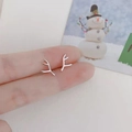 Close-up of minimalist silver reindeer antler earrings held on a finger for size - Antler / Silver
