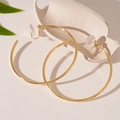 Detail of gold geometric hoop clip-on earrings with clear silicone comfort pads - Round Ear Clip / Gold