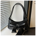 Dettaglio di una borsa a mezzaluna in vernice nera con un grande fiocco decorativo - Nero