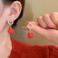 Elegant red resin sphere drop earrings with gold diamond-set studs for festive winter wear - Gold Circle Red Bead Dangle Style (HE18847)