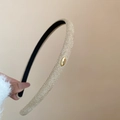 Dettaglio del cerchietto in tessuto testurizzato oro champagne con placca Love - Beige
