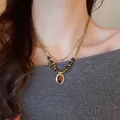 Collier rétro double couche avec œil de tigre et pendentif croix dorée sur pull gris - 15# Collier Or Double Couche Pendentif Croix