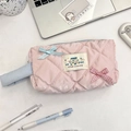 Astuccio trapuntato rosa con fiocchi blu su una scrivania bianca con cancelleria - Quadretti Rosa Chiaro