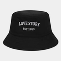 Close-up of Love Story white embroidery on a black cotton bucket hat with parallel stitching - One Size / Black