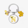 Detail of silver keychain with bee charms and glass dome letter N in honeycomb design - Letter N