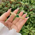Detail of 18K gold-plated open bangle featuring pear-cut emerald and hollow geometric patterns - Style 1-Green Water Drop Stone