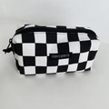 Close-up of a checkered canvas pencil case featuring a black brand tag with zipper detail - Black Checkerboard (Medium)