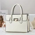 Close-up of white lychee texture handbag featuring black piping and golden hardware lock - White