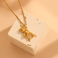 Detailed view of a 3D gold bear pendant on a delicate stainless steel cross chain - Gold (E115)