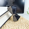 Dettaglio di un elegante fermaglio a banana in raso nero con strass argentati brillanti - Tessuto Nero Con Strass Grigio Trasparente