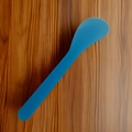 Blue silicone spatula tool for mixing masks with rounded handle on wood texture - Pack of 100 / Transparent Blue