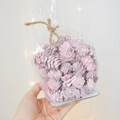 Sachet de pommes de pin naturelles teintes en rose décoré d'une ficelle en chanvre - Petites Particules Roses Un Paquet